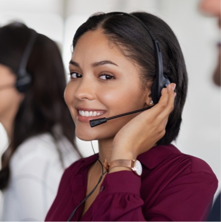 Staff member smiling with headset illustrates the work Confero does in the call center industry providing customer experience research services.