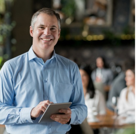 Restaurant employee smiling and interacting with guest is an illustration of the customer experience research options that Confero offers in restaurant & hospitlality industries.