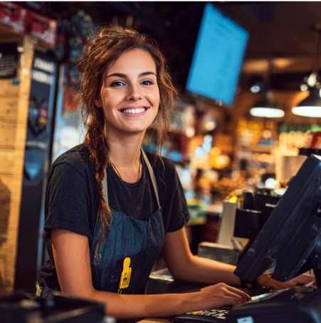 Grocery clerk checking out a customer is an illustration of the customer experience research options that Confero offers in grocery and retail industries.