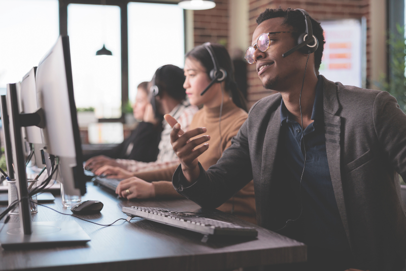 Call center worker smiling and helping a caller to illustrate Confero's customer experience research in call center industry.