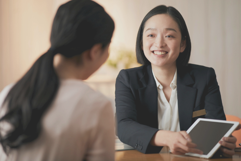 Smiling professional sharing contract details with a client demonstrates Confero's customer experience research in legal and medical industries.