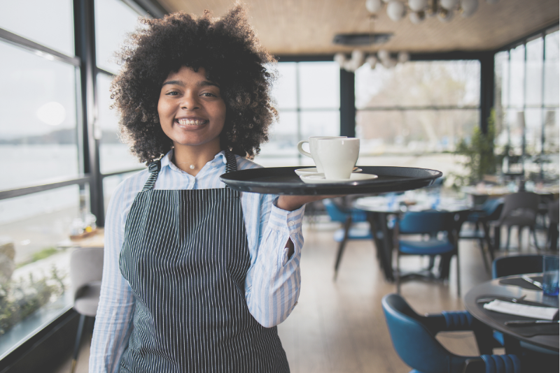 Smiling wait staff welcoming a guest to illustrate Confero's customer experience research in restaurant and hospitality industries.
