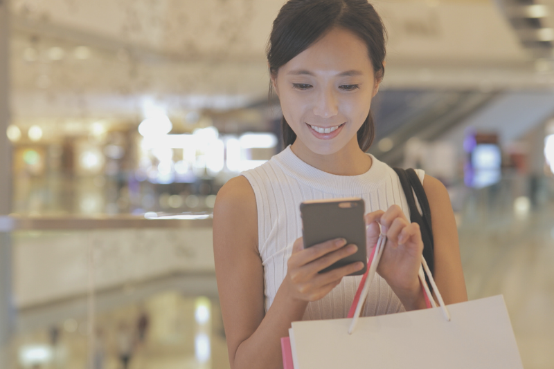 Customer experience researcher entering information in a retail environment to illustrate Confero's customer experience research in retail industry.